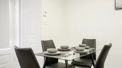 a dining room with a glass table and chairs at Appartement charmant proche des attractions in Montréal