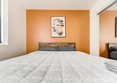 a bedroom with a bed with an orange wall at Appartement central à Montréal - À deux pas de tout in Montréal