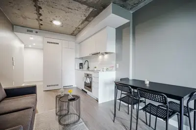 a kitchen and living room with a table and chairs at Studio paisible et central-Montréal in Montréal