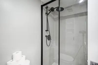 a bathroom with a shower with a toilet and towels at Studio paisible et central-Montréal in Montréal