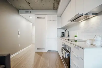a kitchen with white cabinets and a sink at Studio paisible et central-Montréal in Montréal