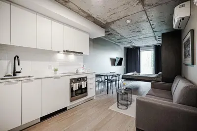 a kitchen and living room with a couch and a table at Studio paisible et central-Montréal in Montréal