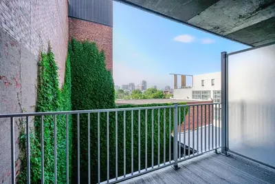 a balcony with green ivy on the side of a building at Studio paisible et central-Montréal in Montréal