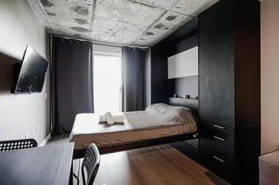 a bedroom with a bed with black walls and a window at Studio paisible et central-Montréal in Montréal