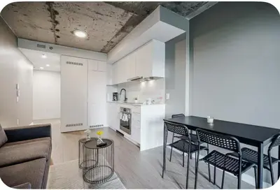 a kitchen and living room with a table and chairs at Studio paisible et central-Montréal in Montréal