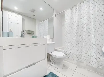 a white bathroom with a toilet and a shower at Appartement au centre-ville in Montréal