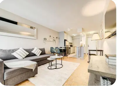 a living room and kitchen with a couch and a table at Appartement au centre-ville in Montréal