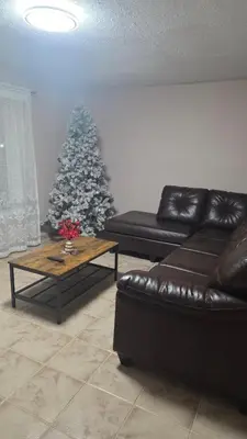 a living room with a couch and a christmas tree at Résidence J'aime in Laval