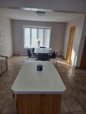 a dining room with a table and chairs in a room at Résidence J'aime in Laval