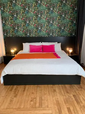 a bedroom with a large bed with pink pillows at Appartements Saint-Alexandre in Longueuil