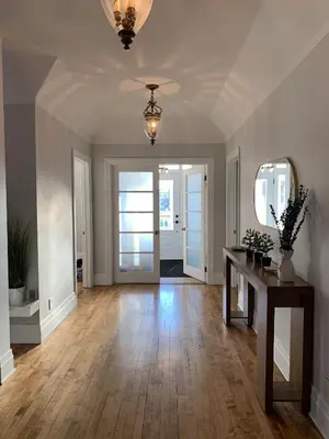 a living room with a table and a mirror at Appartements Saint-Alexandre in Longueuil