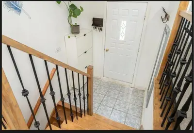 a hallway with a white door and a staircase with a stair case at Lumiere dOrient in Brossard