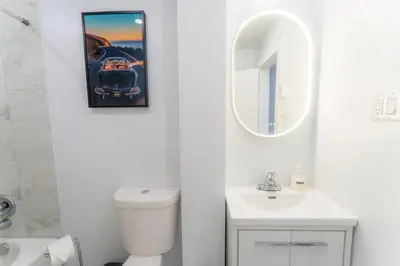 a bathroom with a sink and a car picture on the wall at Ambiance Urbaine À Montréal in Montréal