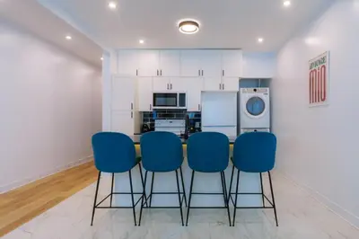 a kitchen with a table and four blue chairs at Ambiance Urbaine À Montréal in Montréal