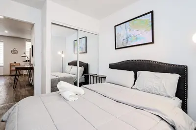 a white bedroom with a bed and a living room at Séjour pratique à Montréal, proche du vieux port in Montréal