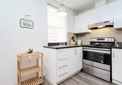 a kitchen with white cabinets and a stove at Séjour pratique à Montréal, proche du vieux port in Montréal