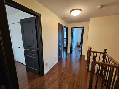 an empty room with a hallway with two doors at 4BR Townhouse 5-Min to DIX30 20-Min to Downtown in Brossard