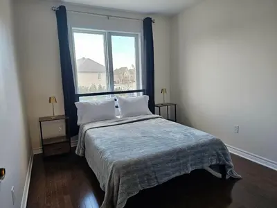 a bedroom with a bed with a large window at 4BR Townhouse 5-Min to DIX30 20-Min to Downtown in Brossard
