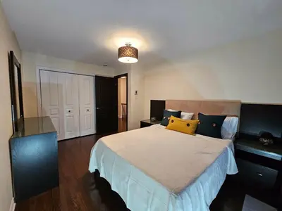 a bedroom with a large bed with blue and yellow pillows at 4BR Townhouse 5-Min to DIX30 20-Min to Downtown in Brossard