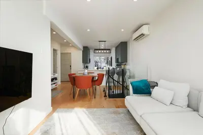 a living room with a white couch and a kitchen at Comfort & Style in Ahuntsic in Montréal