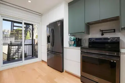 a kitchen with stainless steel appliances and a balcony at Comfort & Style in Ahuntsic in Montréal