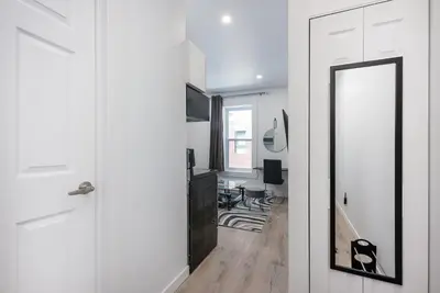 a hallway with a mirror and a white door at Downtown Montreal Lofts Quartier des Spectacles in Montréal