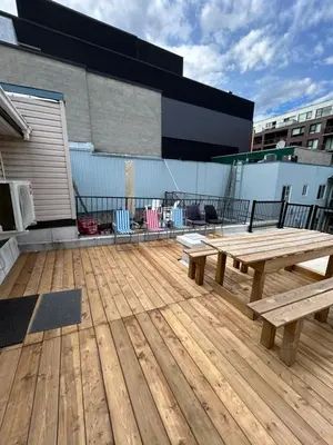 a wooden deck with a picnic table and chairs at Downtown Montreal Lofts Quartier des Spectacles in Montréal