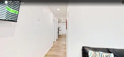 a hallway with white walls and a black couch at Downtown Montreal Lofts Quartier des Spectacles in Montréal