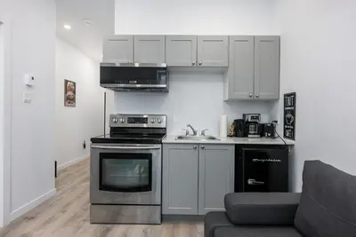 a kitchen with a stove top oven next to a couch at Downtown Montreal Lofts Quartier des Spectacles in Montréal