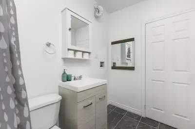 a white bathroom with a sink and a mirror at Downtown Montreal Lofts Quartier des Spectacles in Montréal