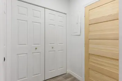 a white closet with white doors and a wooden cabinet at Downtown Montreal Lofts Quartier des Spectacles in Montréal
