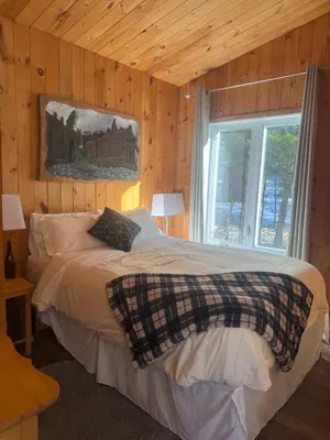 a bedroom with a large bed with a window at Le Richelieu in Saint-Bernard-de-Lacolle