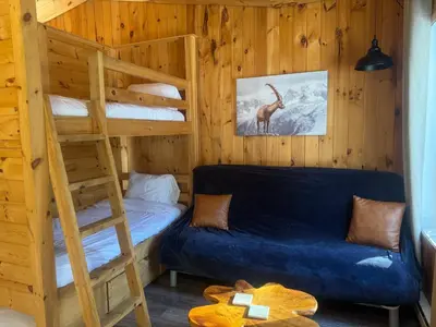 a bedroom with a bunk bed and a blue couch at Le Richelieu in Saint-Bernard-de-Lacolle