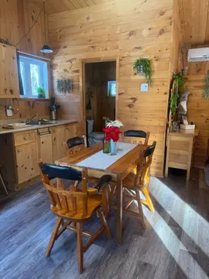 a dining room with a wooden table and chairs at Le Richelieu in Saint-Bernard-de-Lacolle
