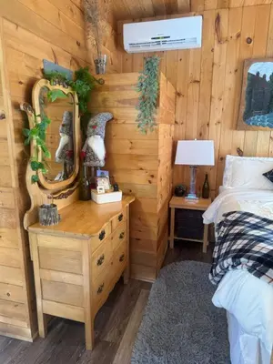 a bedroom with a bed and a wooden wall at Le Richelieu in Saint-Bernard-de-Lacolle