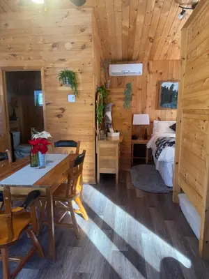 a dining room with a table and a bed in a cabin at Le Richelieu in Saint-Bernard-de-Lacolle
