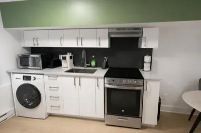 a kitchen with white cabinets and a stove and a sink at Fonctionnal Escape in Trendy Plateau Montreal in Montréal
