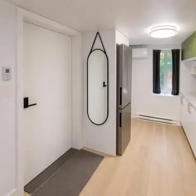 a hallway with a mirror and a refrigerator at Fonctionnal Escape in Trendy Plateau Montreal in Montréal