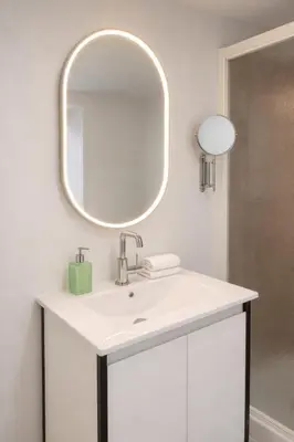 a bathroom with a white sink and a mirror at Fonctionnal Escape in Trendy Plateau Montreal in Montréal