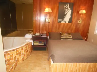 a bedroom with a bed next to a bath tub at Motel Le Paysan in Montréal