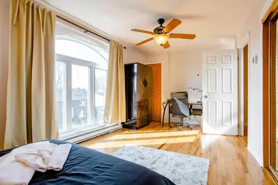 a bedroom with a bed and a ceiling fan at Luxury House Near Montreal Self Check-In in Longueuil