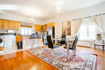 a kitchen and dining room with a table and chairs at Luxury House Near Montreal Self Check-In in Longueuil