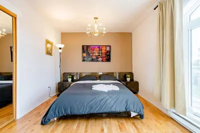 a bedroom with a bed and a chandelier at Luxury House Near Montreal Self Check-In in Longueuil