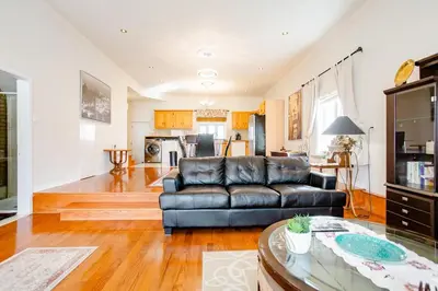 a living room with a leather couch and a table at Luxury House Near Montreal Self Check-In in Longueuil