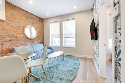 a living room with a blue couch and a brick wall at Mont Royal Suites - M11 in Montréal