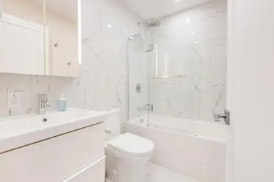 a white bathroom with a toilet and a sink at Mont Royal Suites - M11 in Montréal