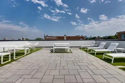 a patio with white chairs and tables on a roof at Mont Royal Suites - M11 in Montréal
