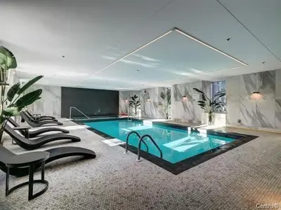 a large swimming pool with chairs and a table at Highrise 1BDR Condo in Downtown Montreal - Long Term Stay by M11 in Montréal