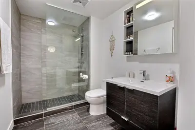 a bathroom with a shower and a toilet and a sink at Highrise 1BDR Condo in Downtown Montreal - Long Term Stay by M11 in Montréal