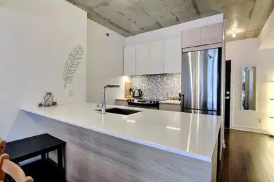 a white kitchen with a sink and a refrigerator at Highrise 1BDR Condo in Downtown Montreal - Long Term Stay by M11 in Montréal